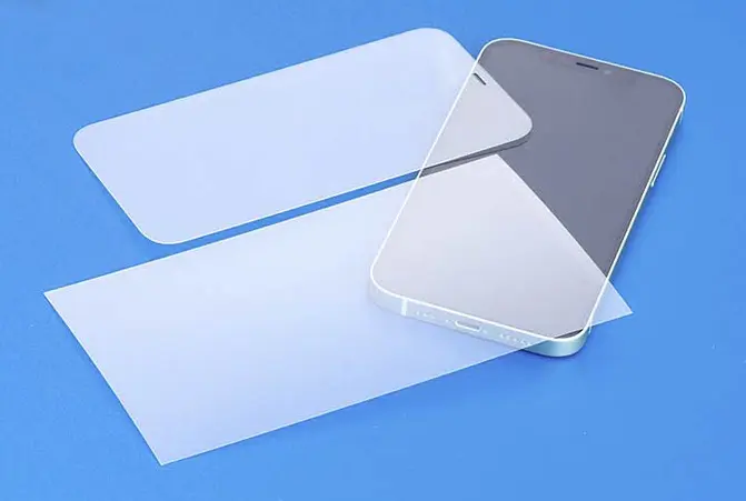 Films protecteurs pour écran et verres trempés de Hama sont posés sur une table. Par-dessus, en transparence, un smartphone.