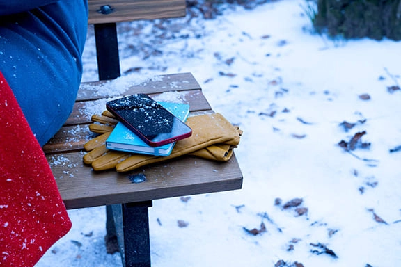 Un téléphone est posé sur le banc d’un parc, dans le froid