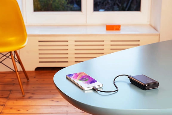 Une batterie externe charge un téléphone sur une table