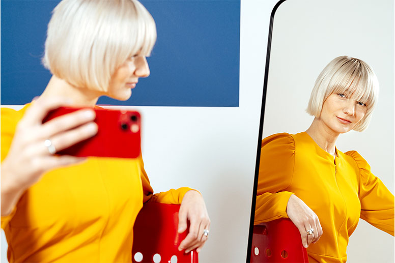Selfie au-dessus des épaules, le regard vers un petit miroir.