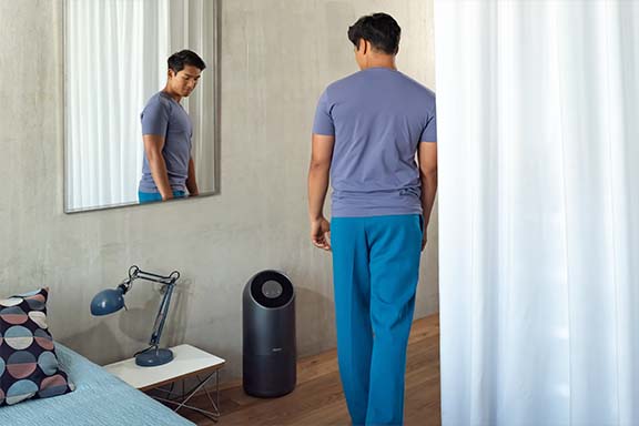 Une personne se tient devant un ventilateur intelligent.