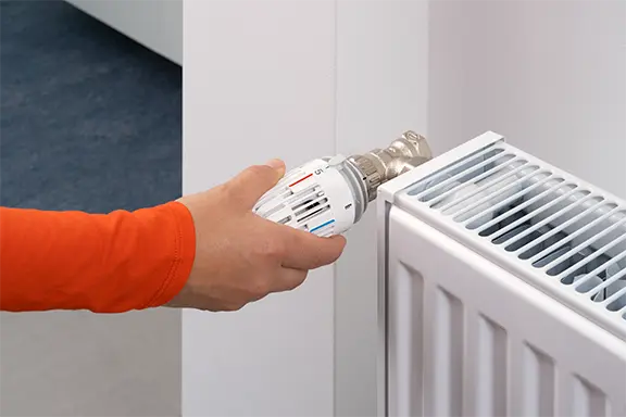 La personne ouvre le thermostat.