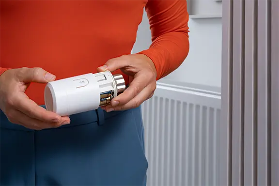 Person schaltet das Thermostat ein.