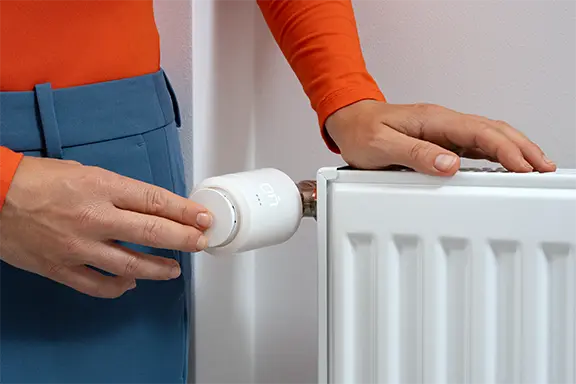 Person nimmt das Thermostat in Betrieb.