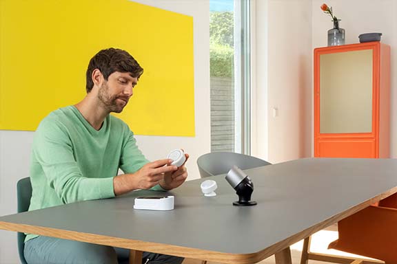 Personne avec différents produits Smart Home.