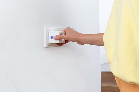 Une personne branche une prise Wi-Fi dans une prise murale.