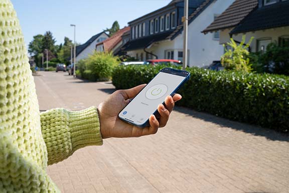 Une personne utilise une application pour contrôler une prise électrique.